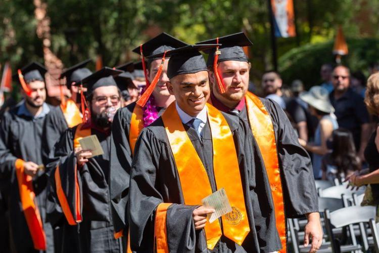 students walk at commencement ceremony