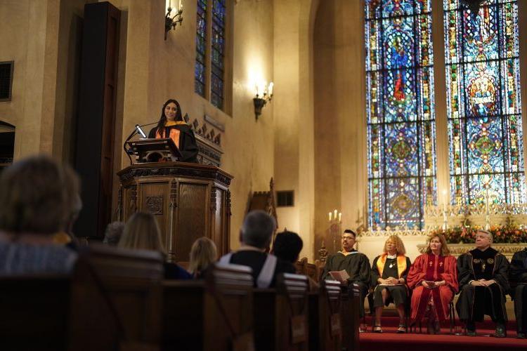 a student stands at a podium inside Morris Chapel