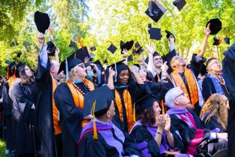 Graduates throw their caps in the air.